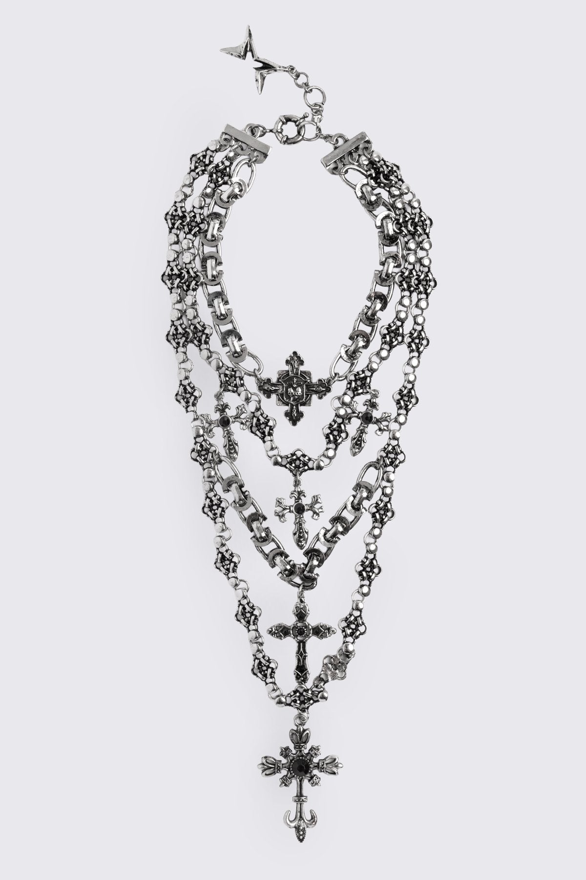 Layered necklace in antique-silver plated metal with mixed cross pendants and chains, in a goth grunge style.