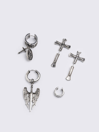 A 5-piece set of mismatched silver-toned earrings and an ear cuff featuring gothic and religious motifs, including crosses, a Virgin Mary medallion, and a winged sword dangle.