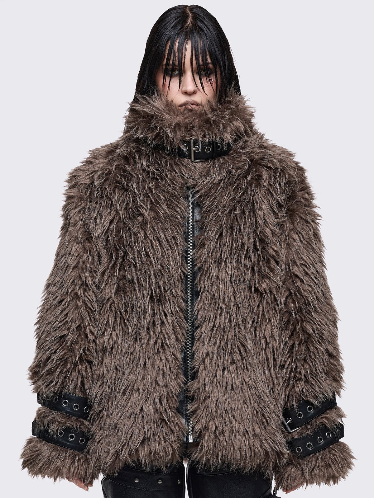 Voluminous oversized brown faux fur jacket featuring long-pile shaggy texture and a high-neck funnel collar.