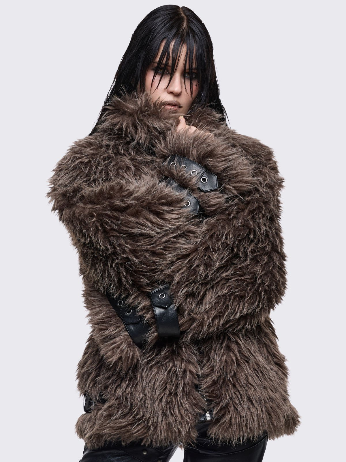 Voluminous oversized brown faux fur jacket featuring long-pile shaggy texture and a high-neck funnel collar.