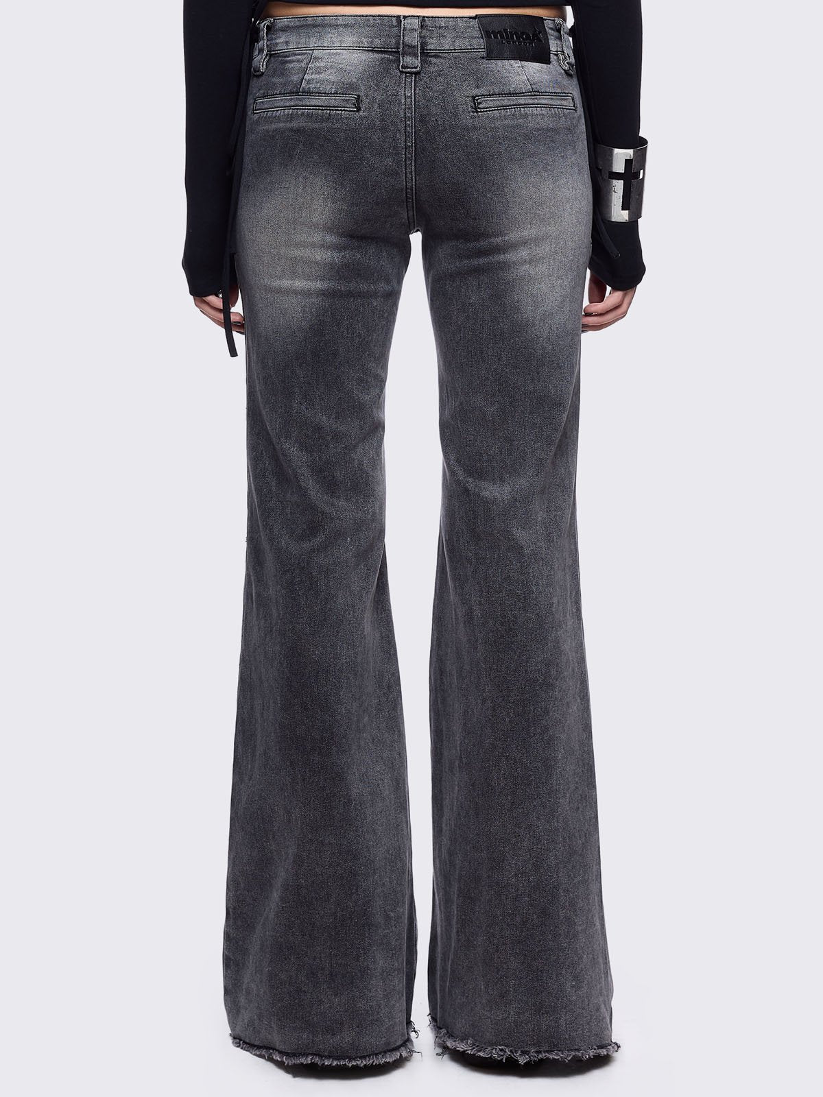 Grey flared jeans with light grey overdye featuring a chunky buckle belt and distressed seams details.