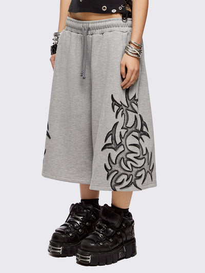 Grey oversized longline sweat shorts with sigilism graphic print.