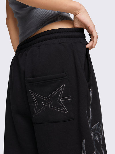 Black oversized longline sweat shorts with sigilism graphic print.