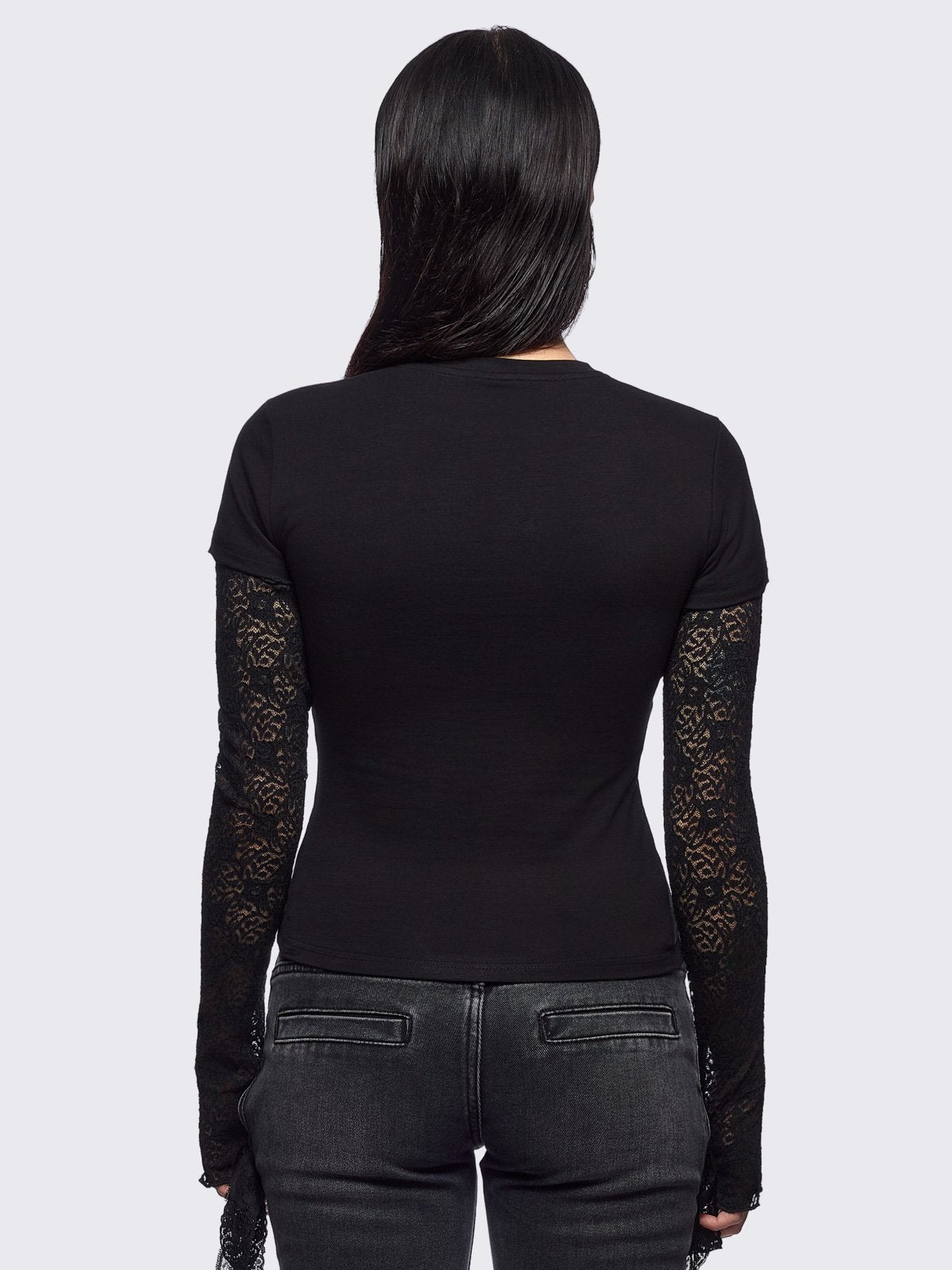 Black layered long sleeve baby tee featuring a grunge sigilism graphic front print and lace contrast sleeves with thumbhole cuffs.