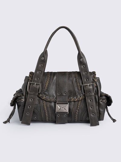 Brown faux leather shoulder bag featuring lace ups, eyelets, buckles and multiple pockets.