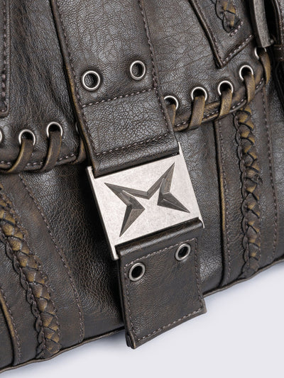 Brown faux leather shoulder bag featuring lace ups, eyelets, buckles and multiple pockets.