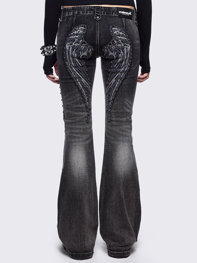 Black washed flared jeans featuring wings back and cross front embroideries and stud trim and details
