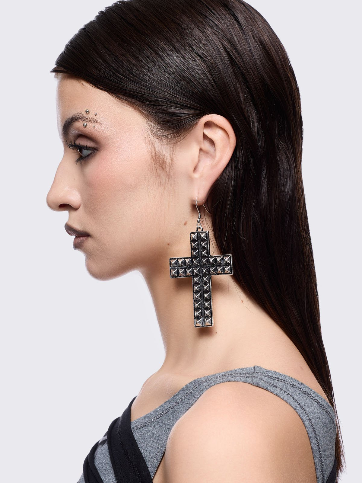 Silver dangle earrings featuring a studded cross design pendants