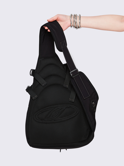 Black nylon sling bag featuring contrast stitching, multiple zip pockets and front bungee-cord detail.