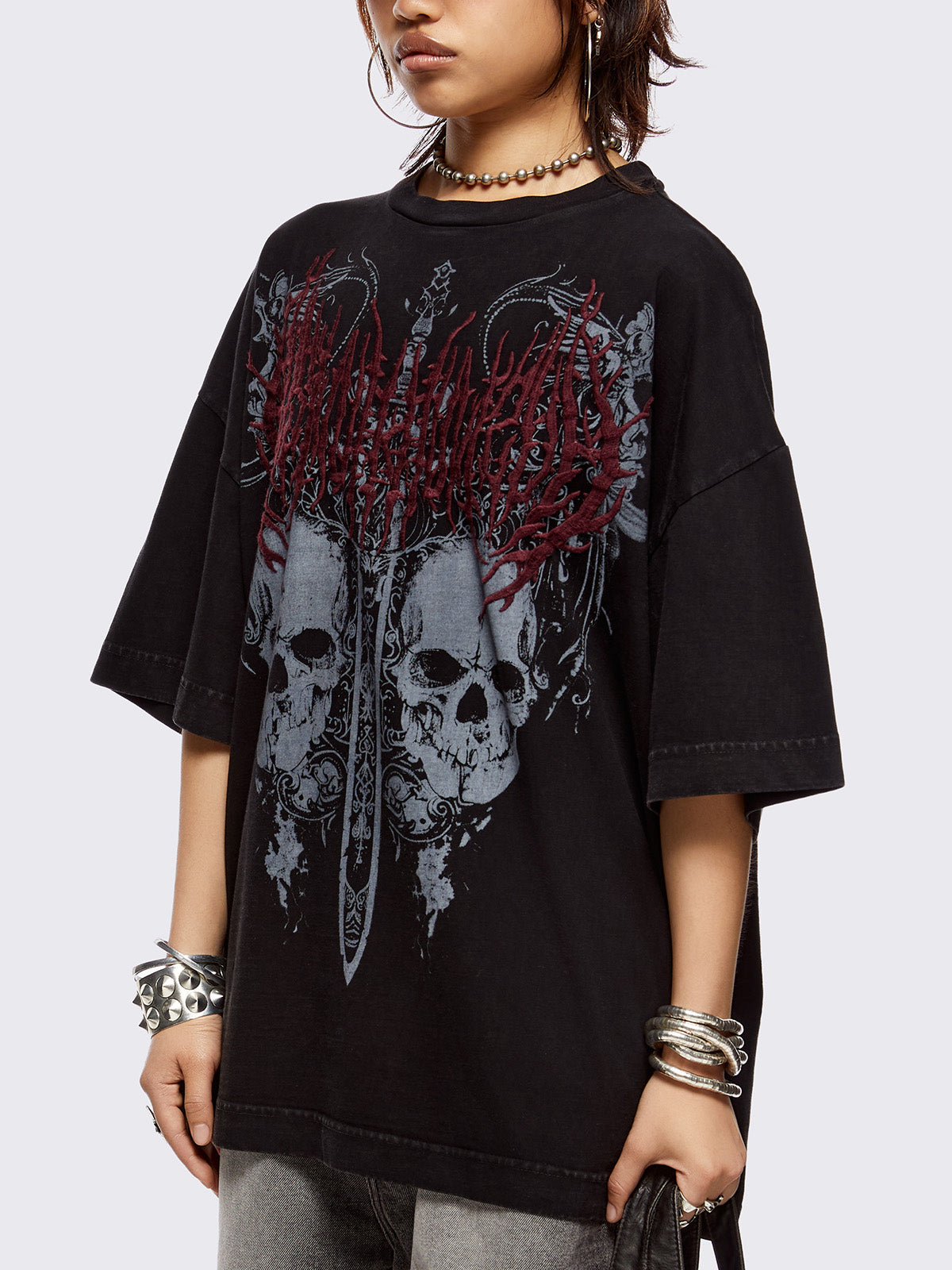 Black washed t-shirt with skulls and sword graphic front print and red embroidery.