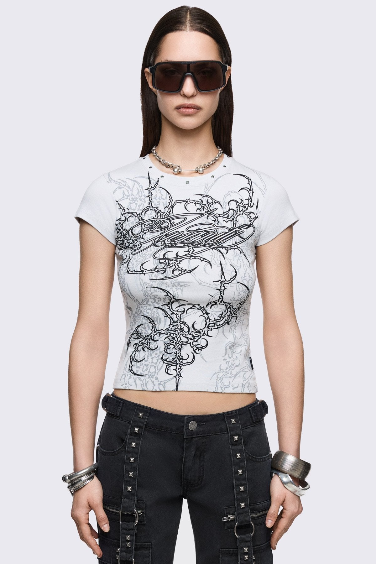 White cotton baby tee with Insanity sigilism graphic print and silver stud details, grunge Y2K aesthetic.