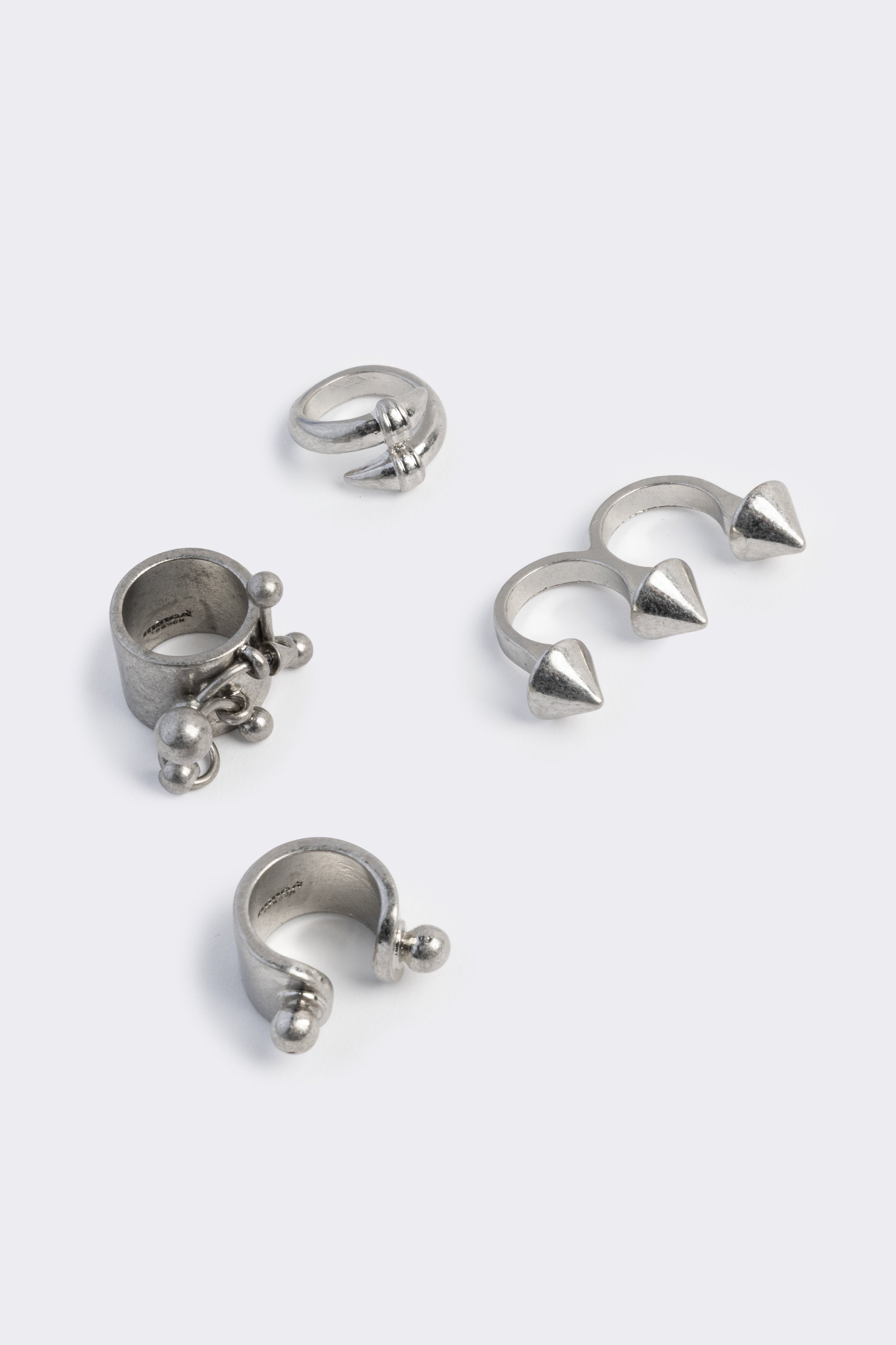 Set of 4 silver rings featuring piercing and spike designs