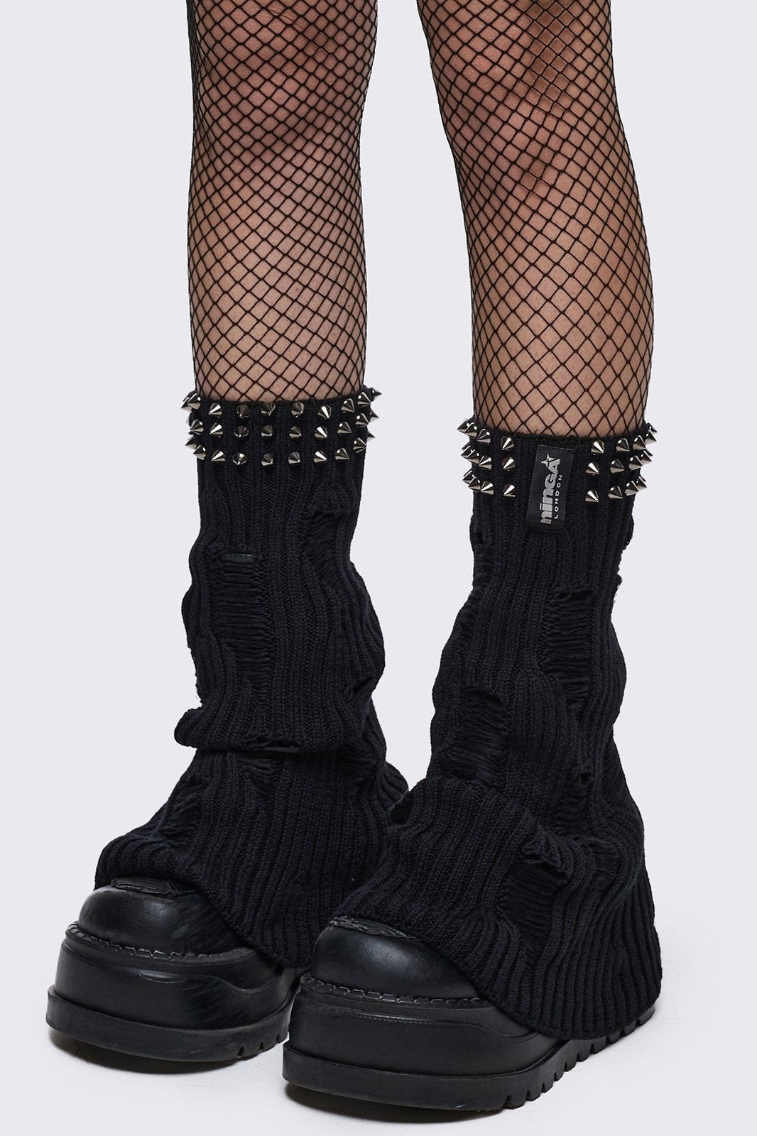 Black knitted flare leg warmers with spiked trim and distressed details.