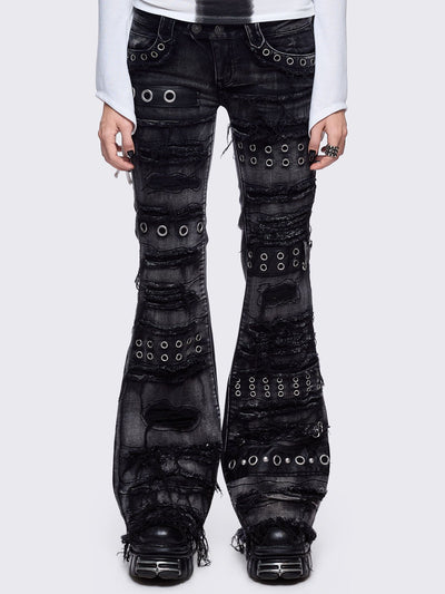 Black washed flare jeans featuring heavy distressed and shedded, eyelet, piercing and stud details. 