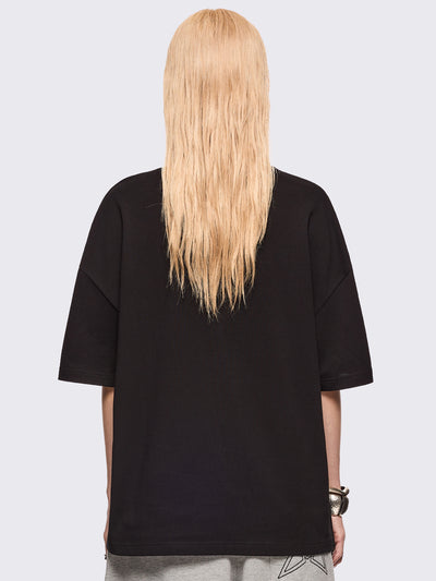 Black oversized t-shirt with "Seen this angel?" and a girl angel graphic print and pink stud and embroidery details.