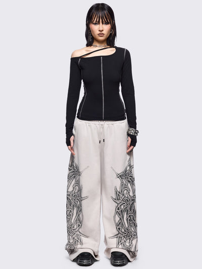 Black cold shoulder top with cut out details and white contrast stitching.