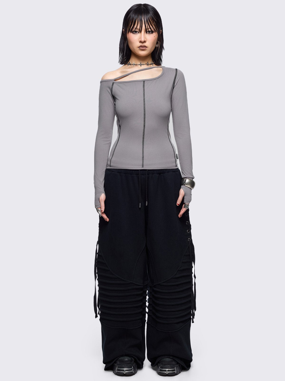 Grey cold shoulder top with cut out details and black contrast stitching.