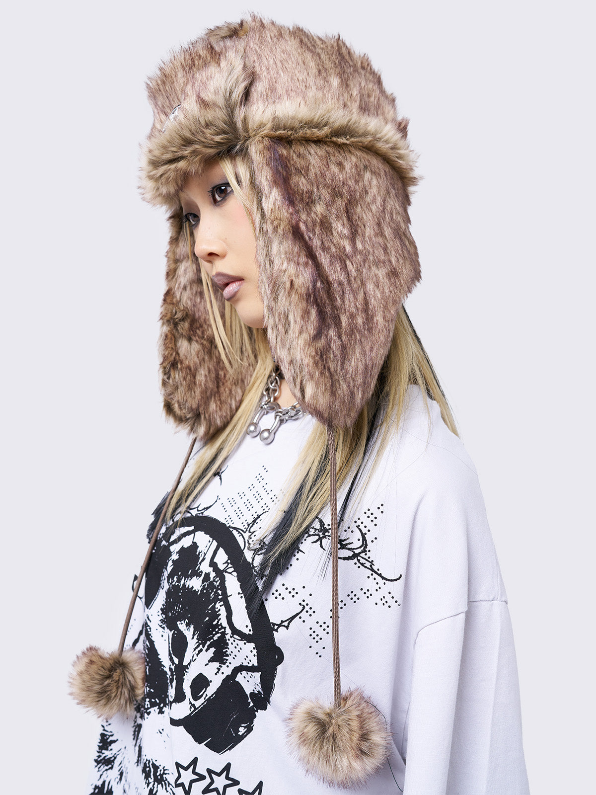 Beige faux fur trapper hat with minga rubber logo detail and ear flaps