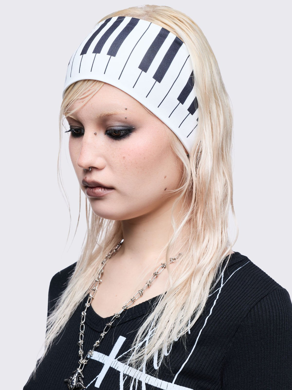White wide headband with piano graphic print. 