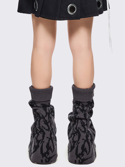 Grey flared leg warmers with black sigilism graphic design.