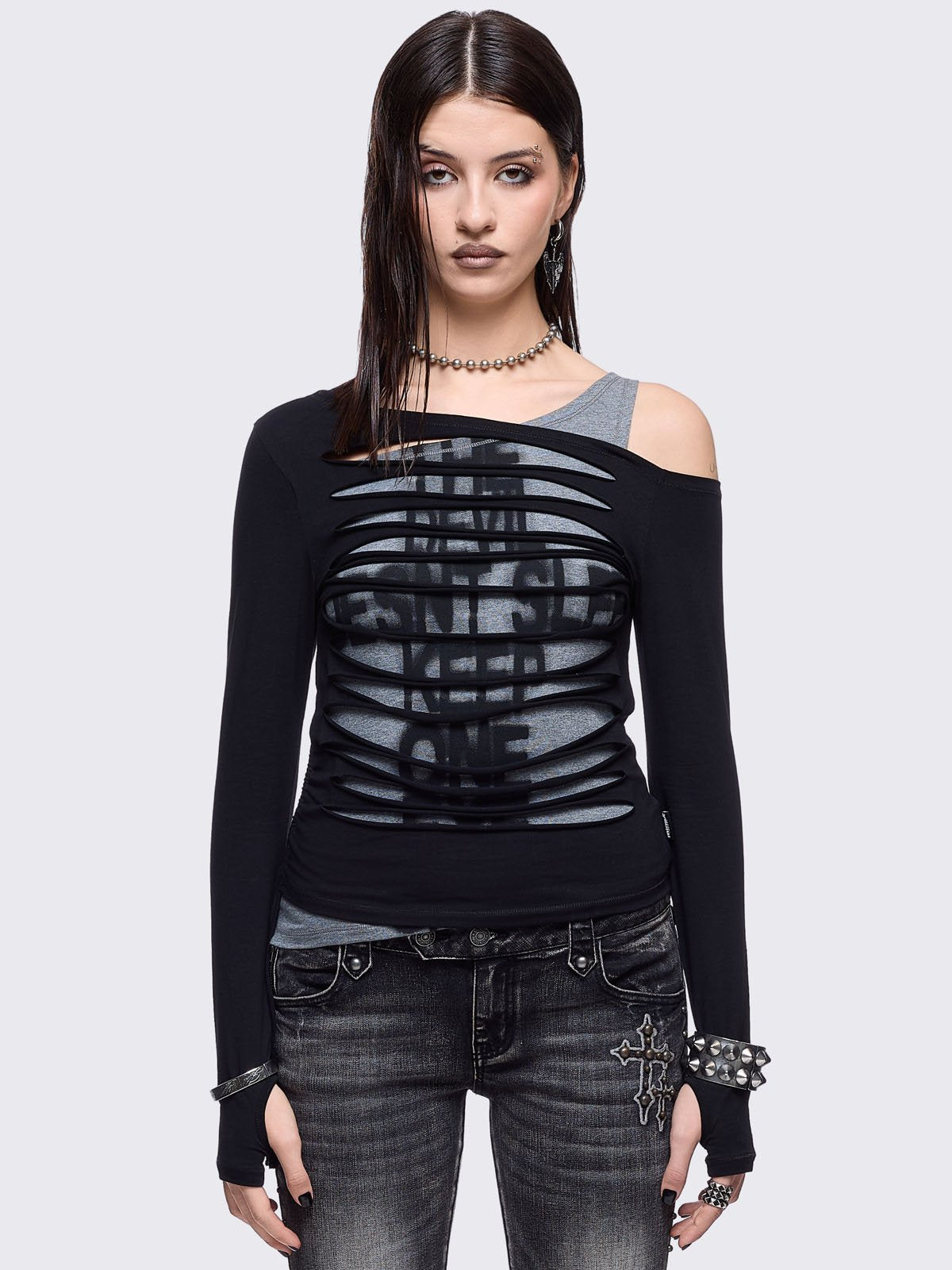 Black and grey long sleeve layered cold shoulder top featuring a front cut-out slash details and a grunge graphic print. 