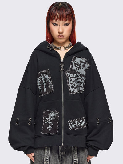 Black zip up hoodie jacket with white grunge print patches and eyelets with O-ring and piercing details.