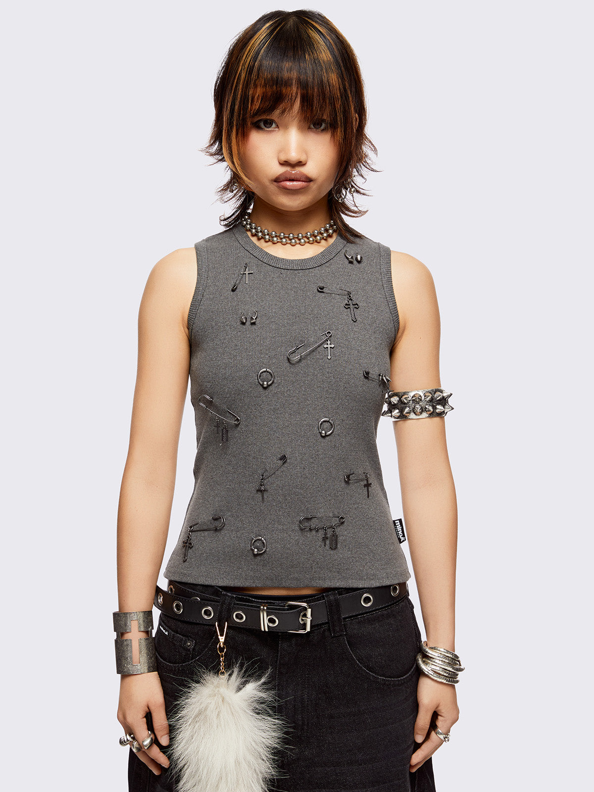 Sleeveless grey tank top with safety pins and piercing details. Grunge-style vibes. 