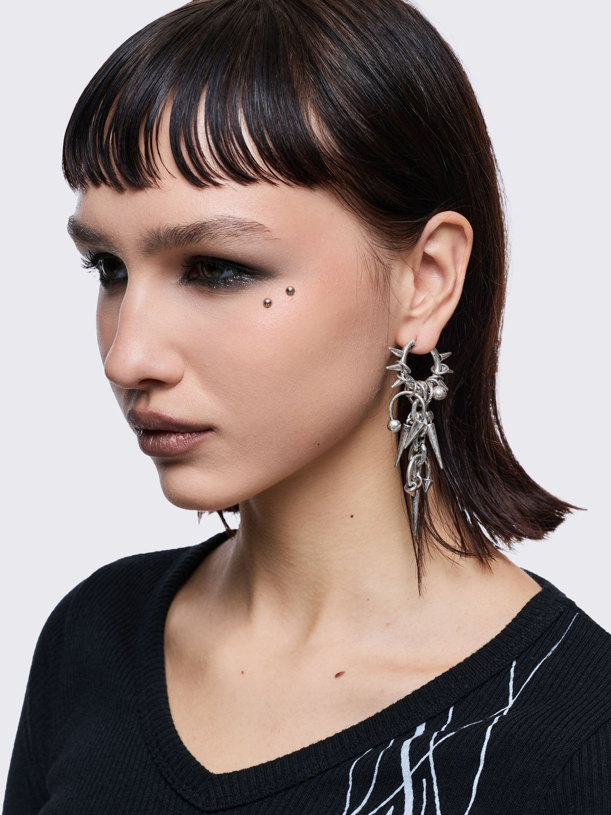 Silver chunky hoop earring with spike and piercing pendants.
