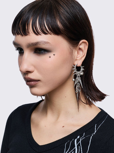 Silver chunky hoop earring with spike and piercing pendants.