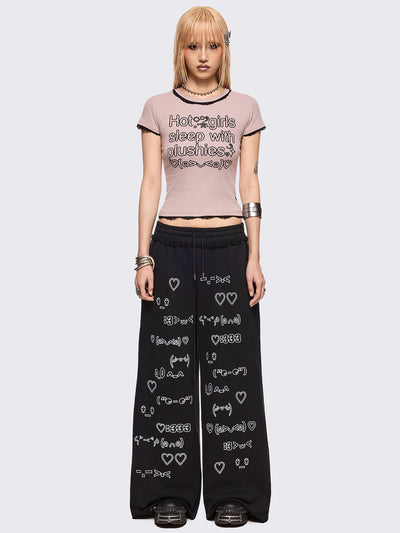 Baby pink graphic baby tee with "Hot girls sleep with plushies" graphic front print and black lace trims at seams.