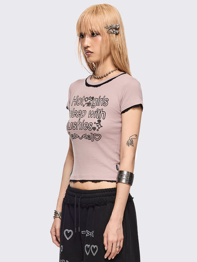 Baby pink graphic baby tee with "Hot girls sleep with plushies" graphic front print and black lace trims at seams.