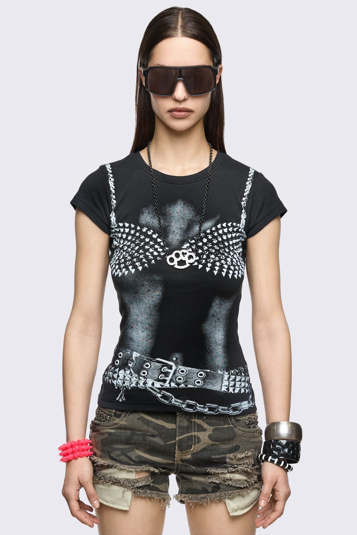 Black cotton baby tee with trompe l'oeil studded bra and belt graphic, slim fit in a grunge Y2K style.