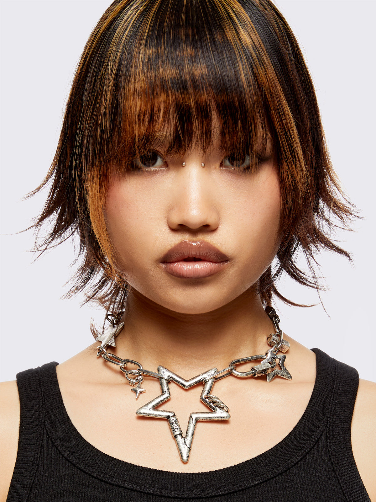 Chunky star charm necklace featuring chain with star and hook details.