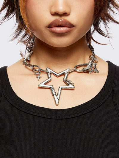 Chunky star charm necklace featuring chain with star and hook details.