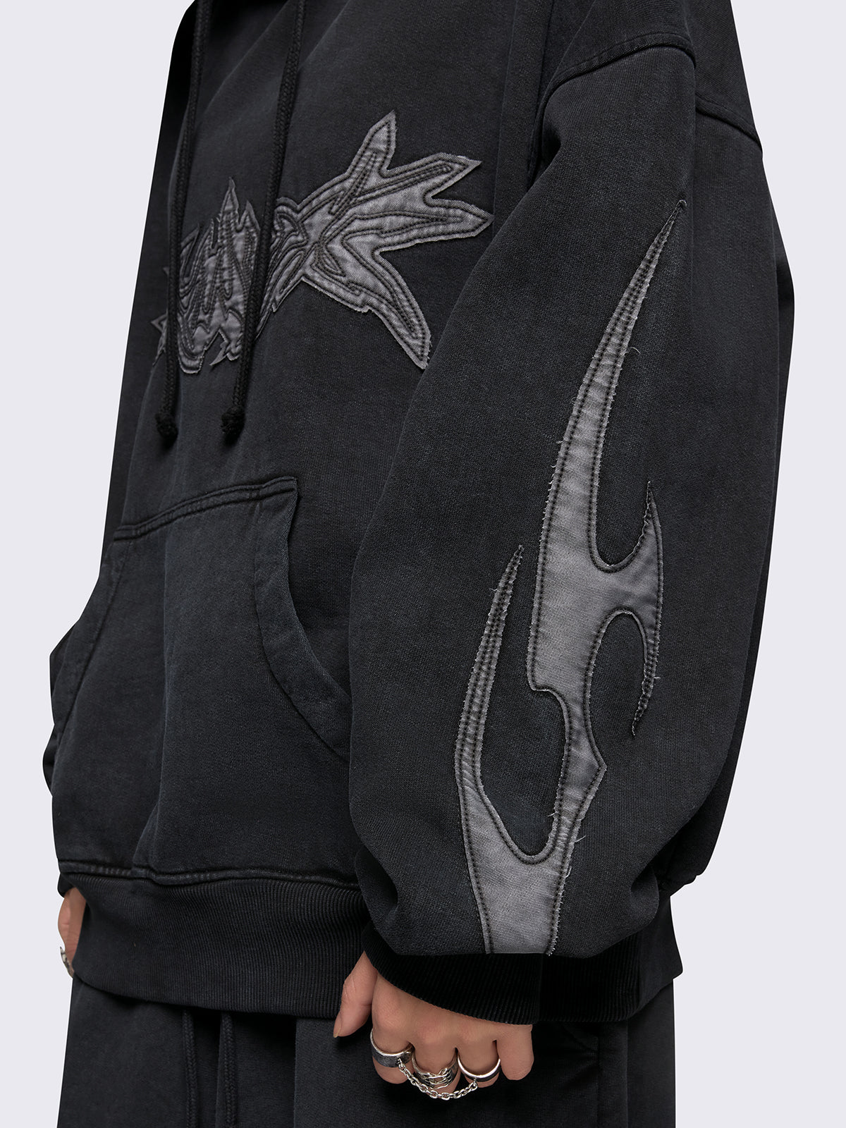 Black washed hoodie with grey sigilism embroidered patches, drawstring hood, and kangaroo pockets