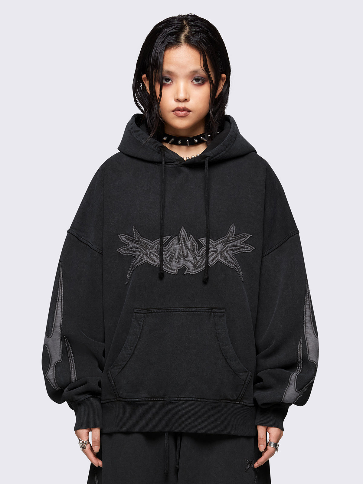 Black washed hoodie with grey sigilism embroidered patches, drawstring hood, and kangaroo pockets