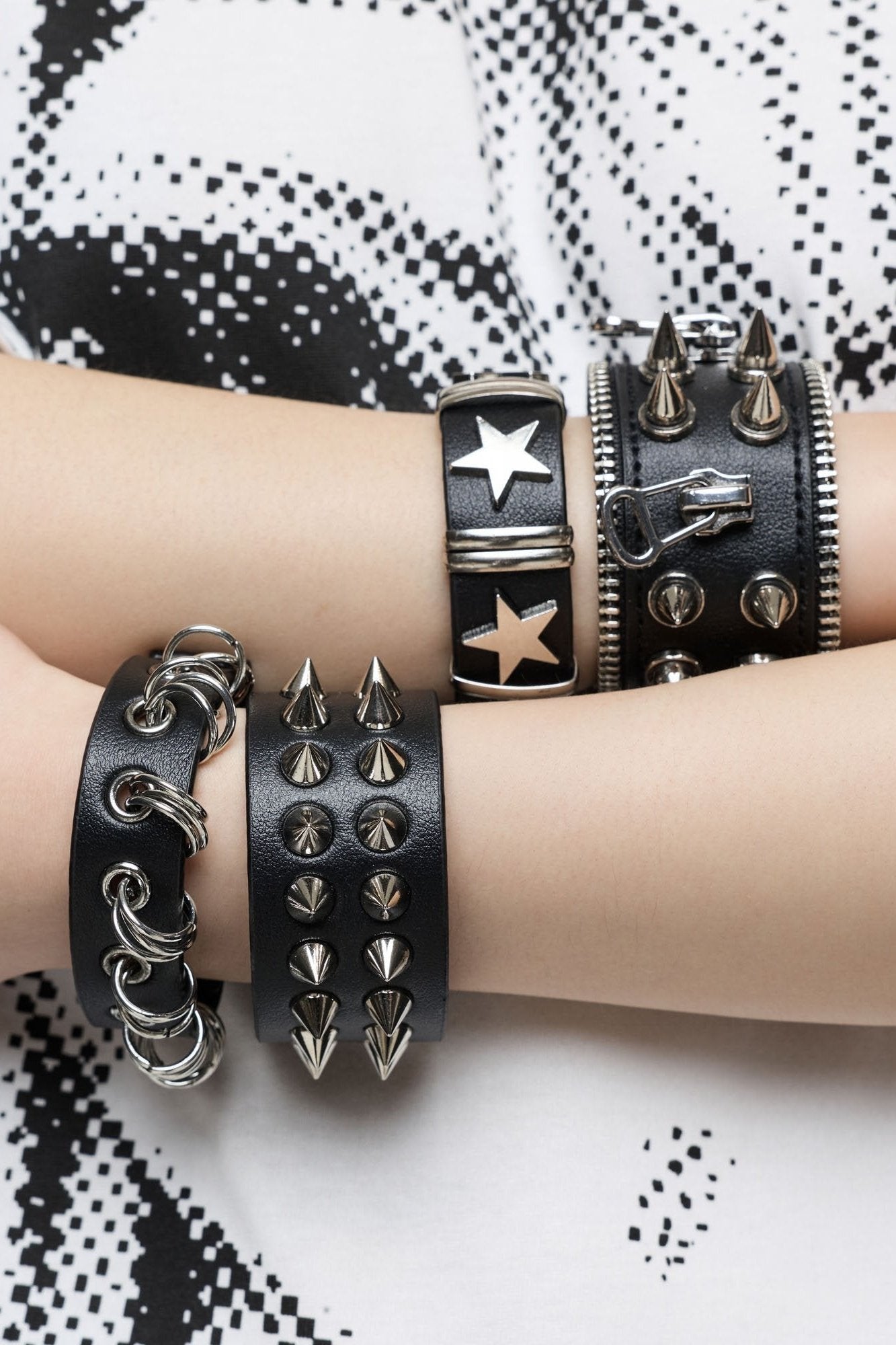 Set of 4 PU bracelets with mix of spikes, stars, zippers and studs. 