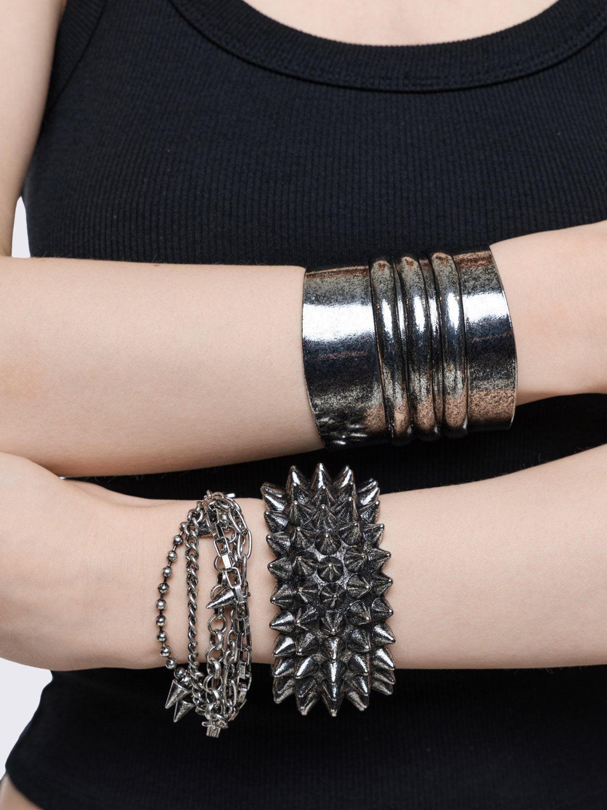 Set of 3 silver bracelets: a wide architectural cuff, a multi-row spike band, and a layered chain bracelet