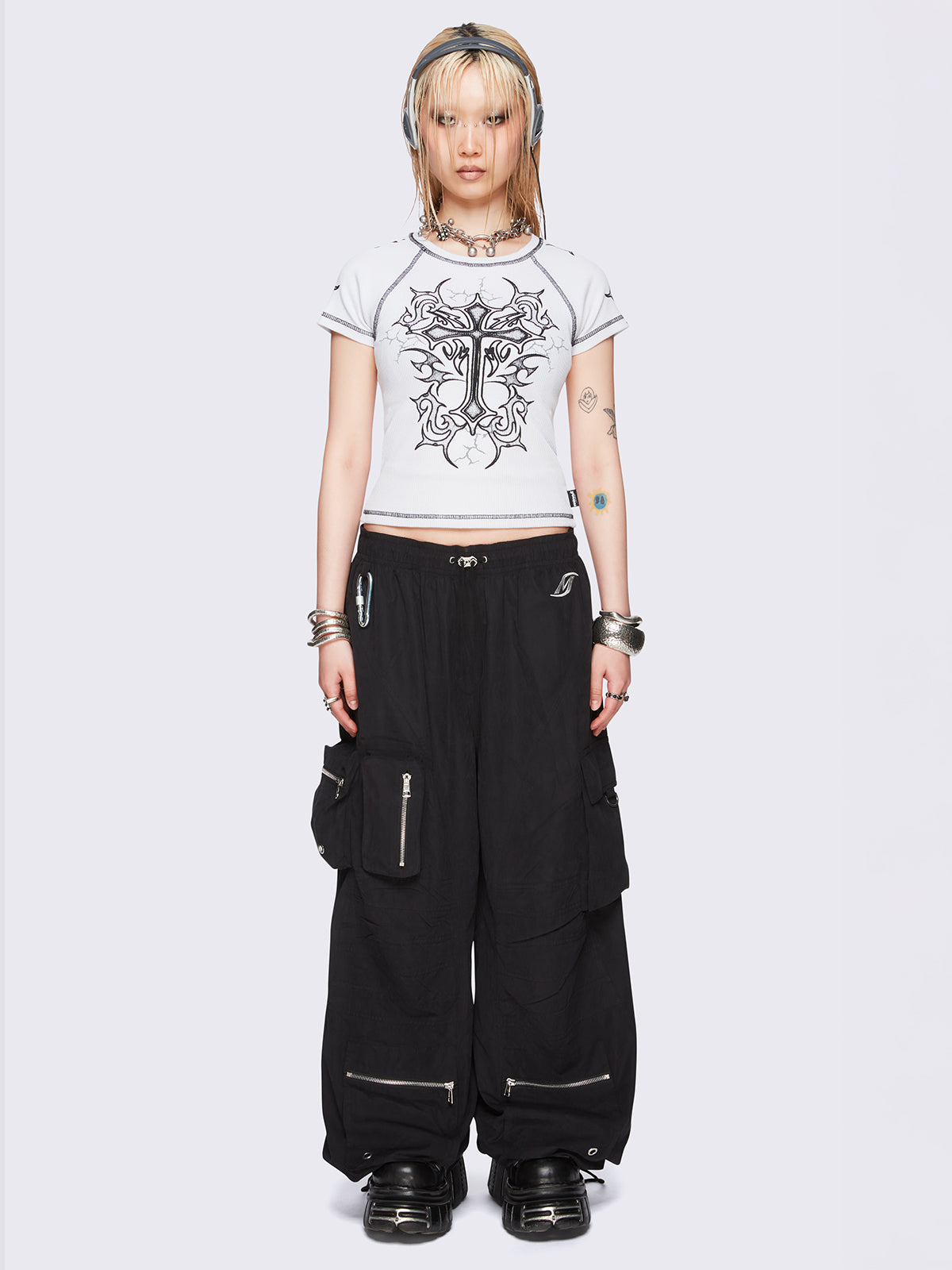 Black tech cargo parachute pants featuring multiple utility pockets with zipper and carabiner hardware detail - edgy, utility-inspired streetwear style.