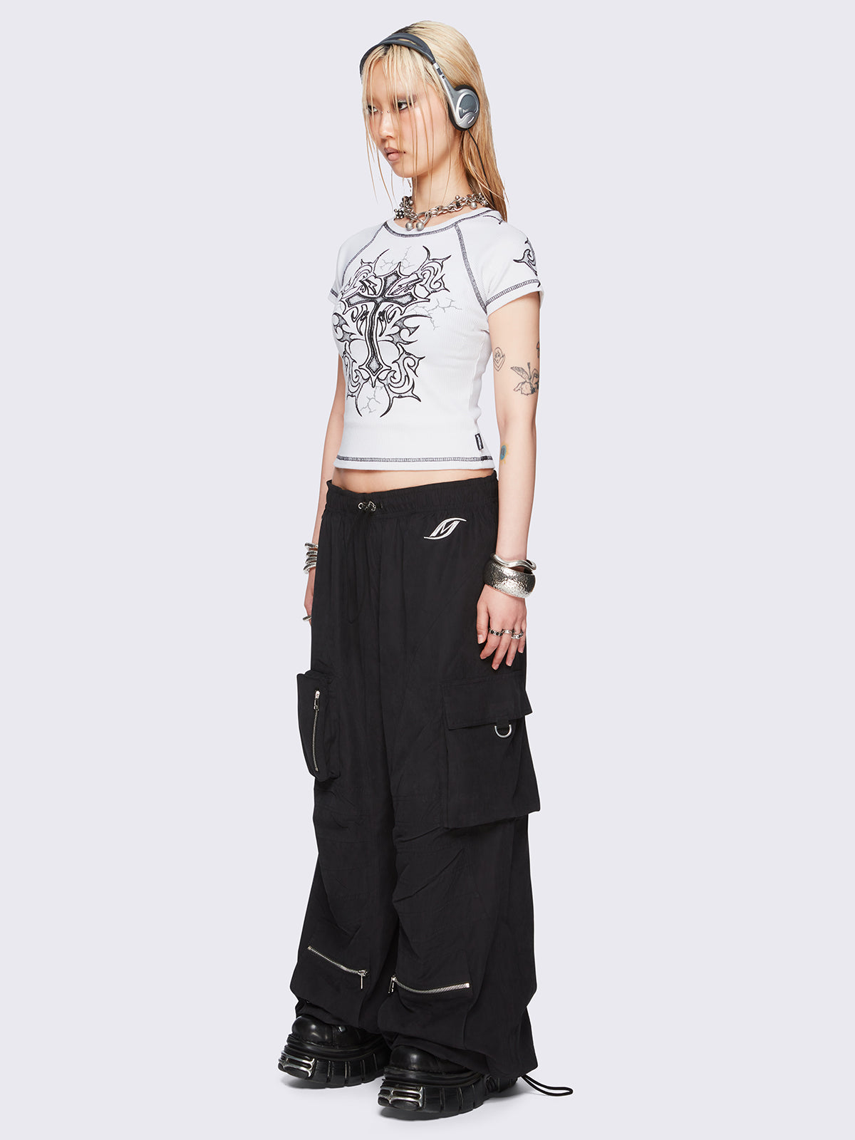 Black tech cargo parachute pants featuring multiple utility pockets with zipper and carabiner hardware detail - edgy, utility-inspired streetwear style.
