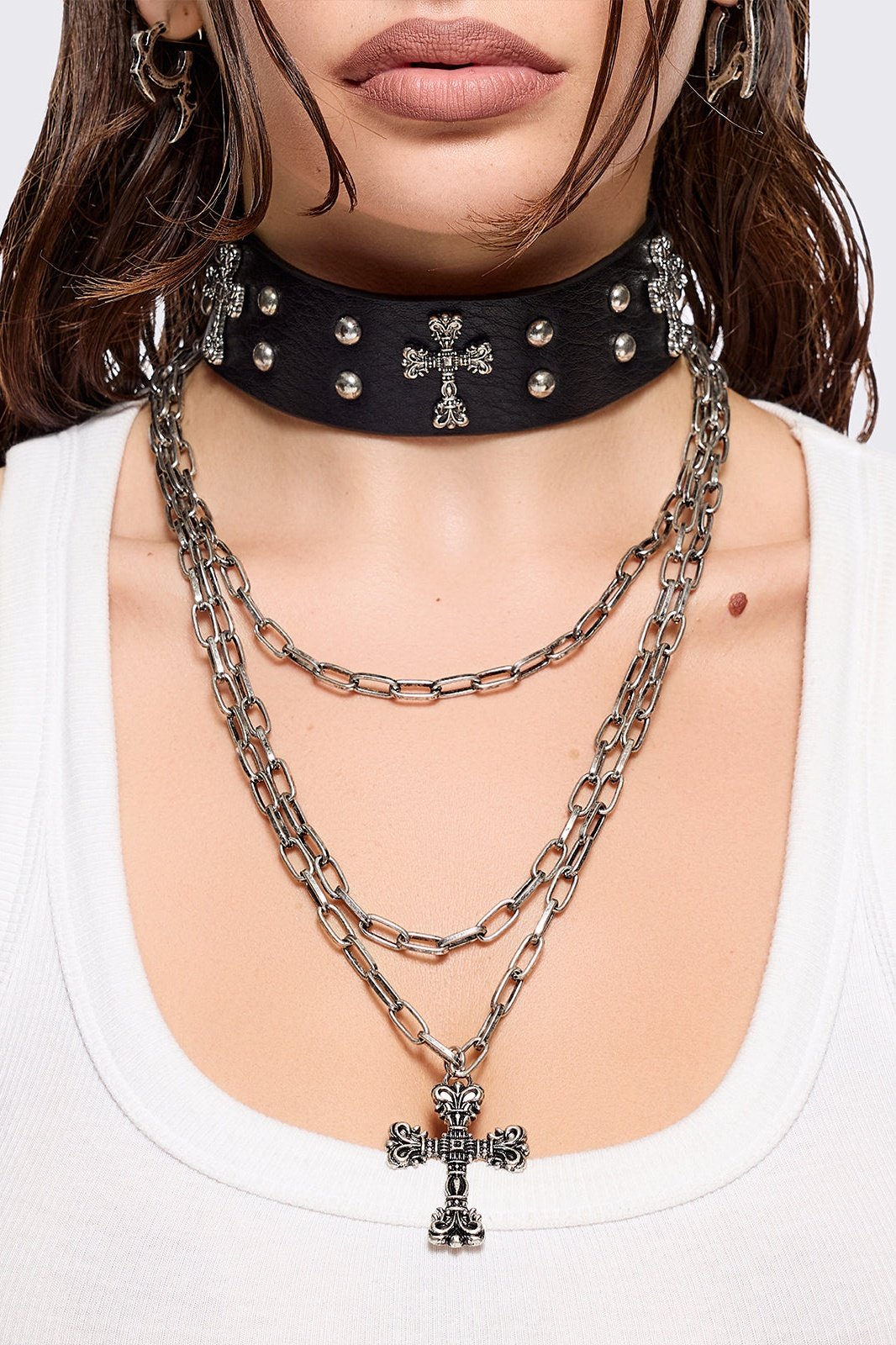 Set of 2 necklaces: One black PU choker with crosses and studs and other silver multiple chain with cross pendant.