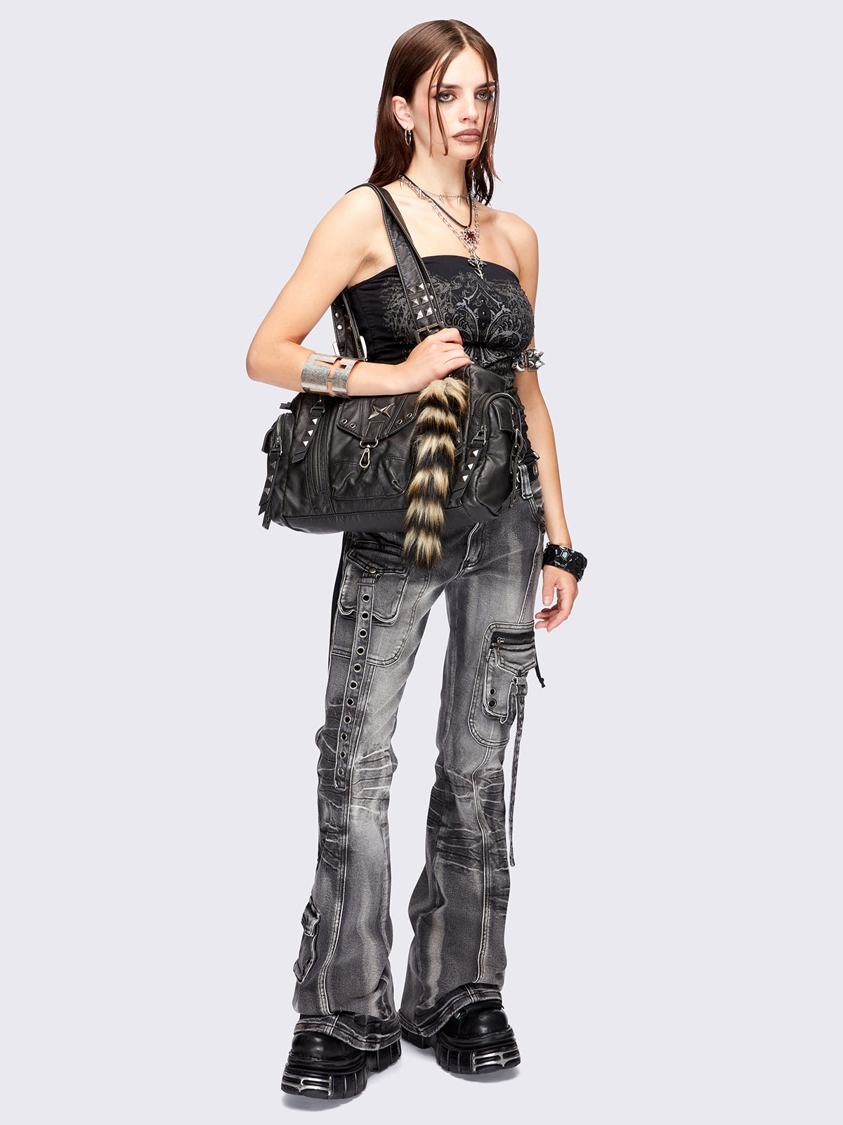 Black faux leather shoulder bag with pyramid studs, metal hardware details and removable faux fur fox tail keychain.