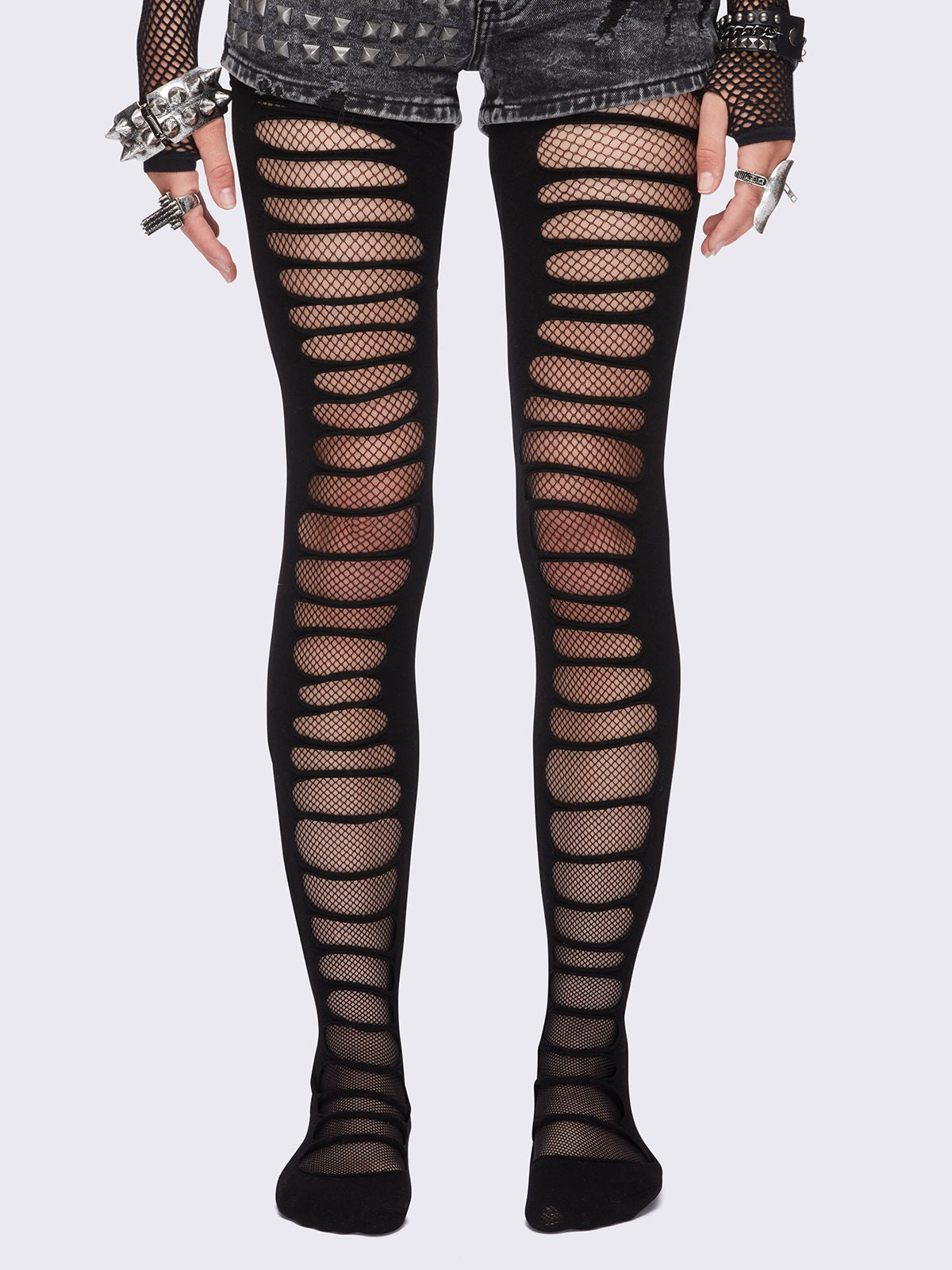 Black slashed cut-out tights with fishnet layer underneath.