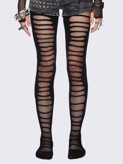 Black slashed cut-out tights with fishnet layer underneath.