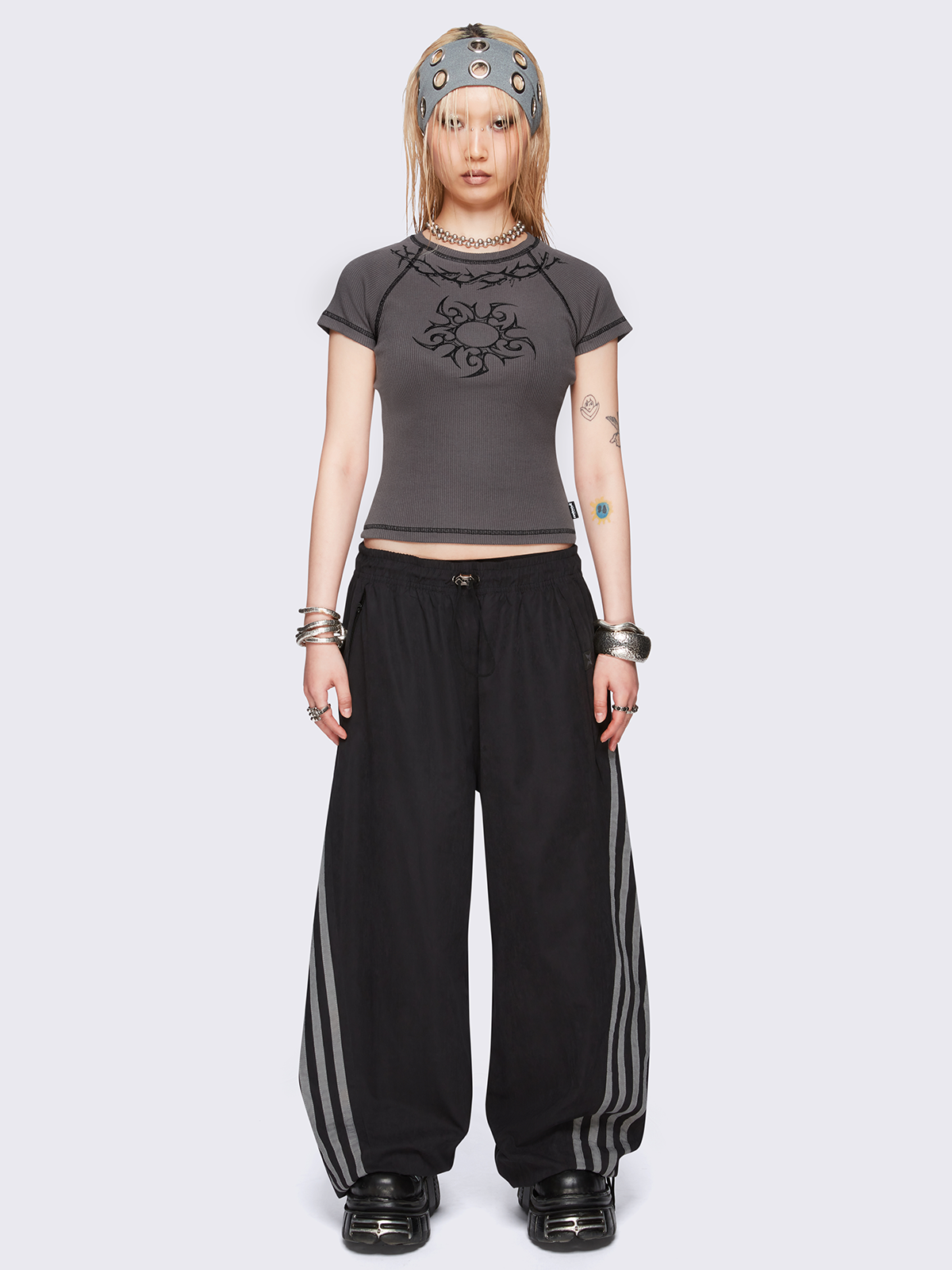 Grey graphic baby tee with tribal sun and thorns print and black contrast stitching.