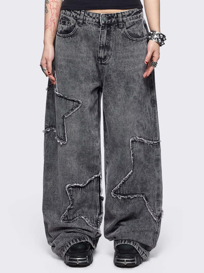 Grey washed baggy jeans with frayed star patches.