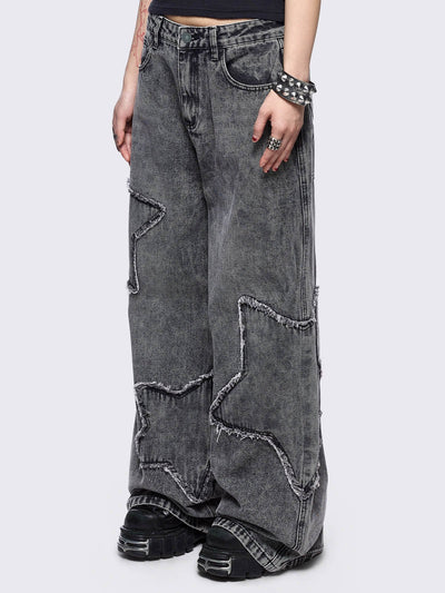 Grey washed baggy jeans with frayed star patches.