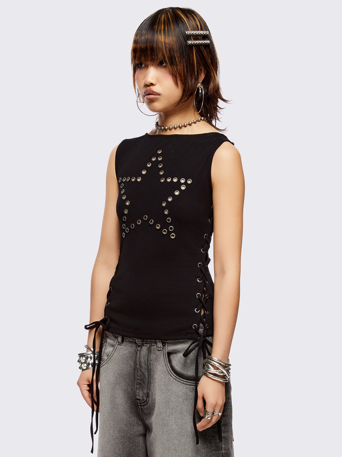 Black tank top with star-shaped eyelet detail and adjustable lace-up sides.