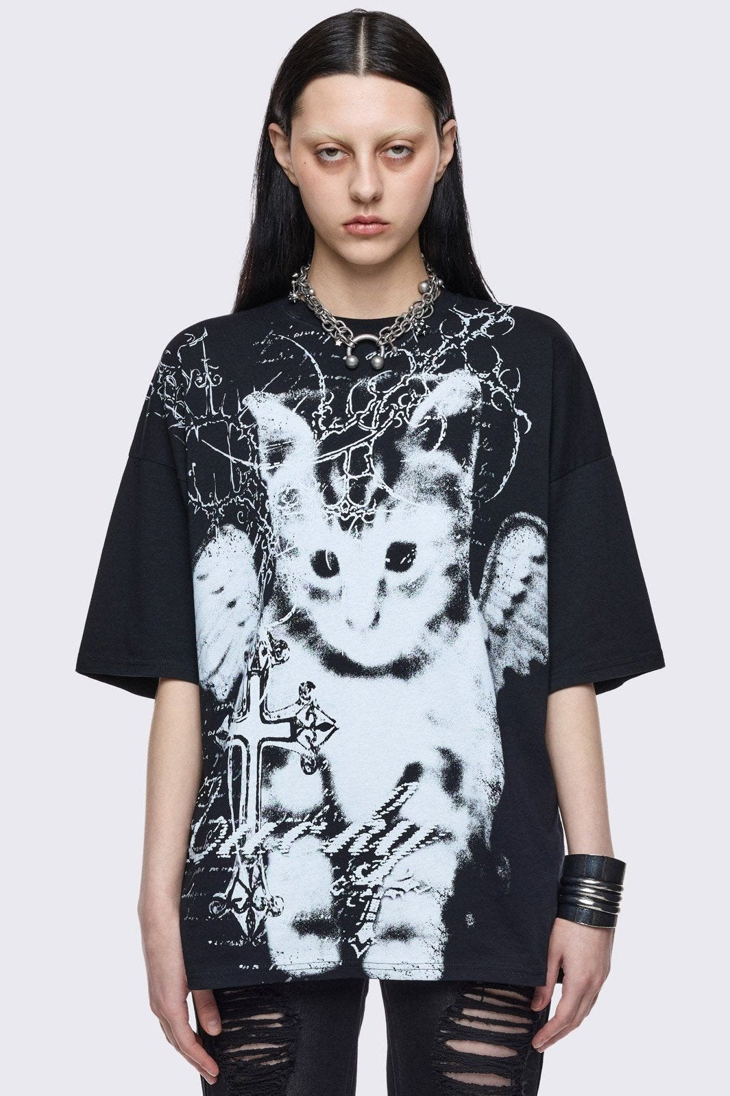 Black oversize graphic t-shirt with winged cat and crosses graphic front print.