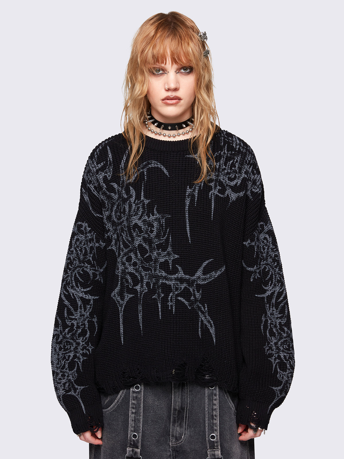 Black knitted sweater with a bold tribal sigilism graphic print. Chunky ribbed knit with distressed details, perfect for grunge and Y2K alt fashion aesthetics.